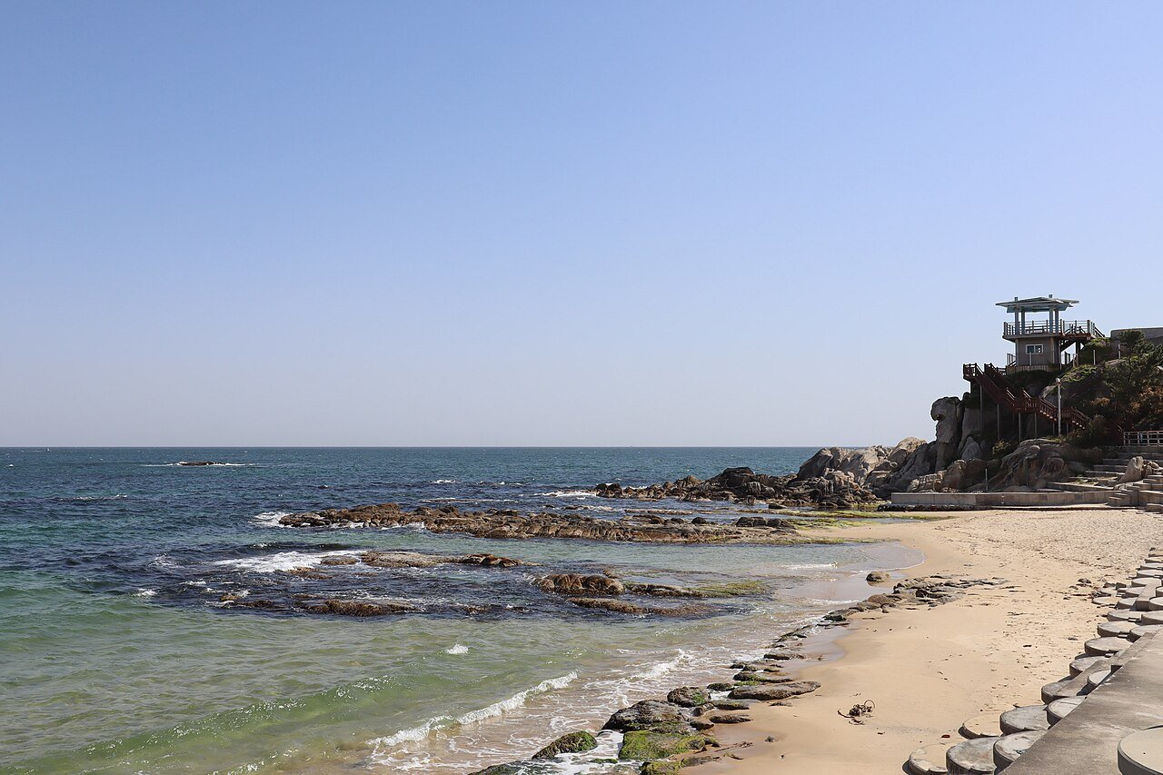 Wide sandy shore and blue water at Jumunjin Beach in Gangneung, Korea