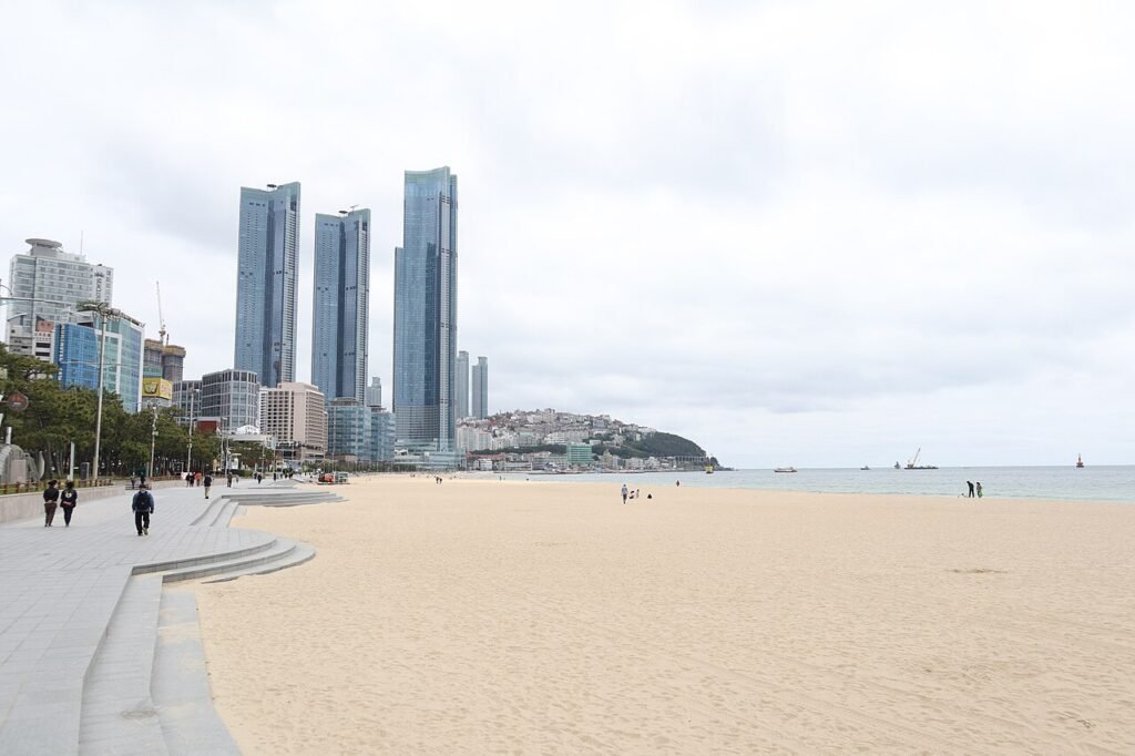 Wide sandy stretch of Haeundae Beach in Busan with the city skyline behind