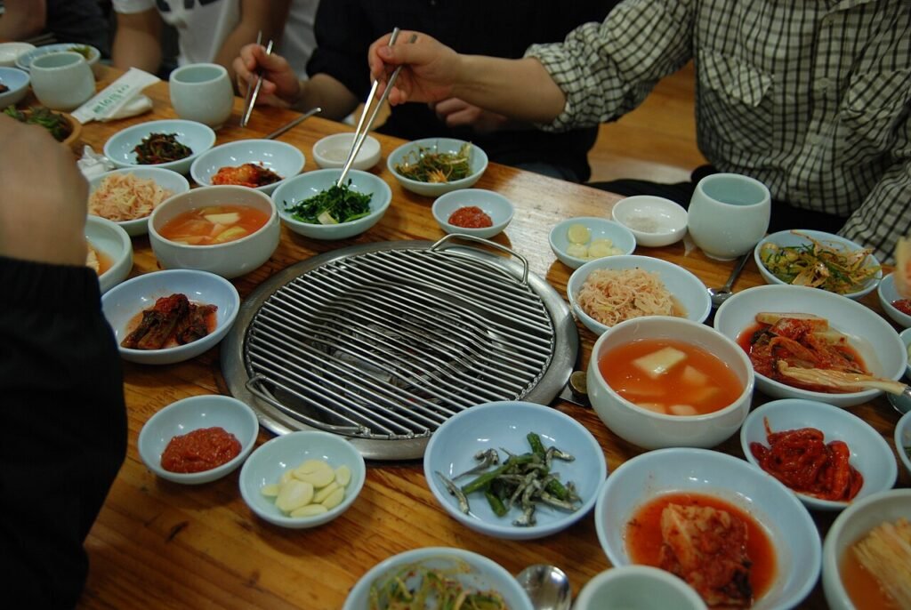 A Korean tabletop barbecue grill surrounded by side dishes (banchan)