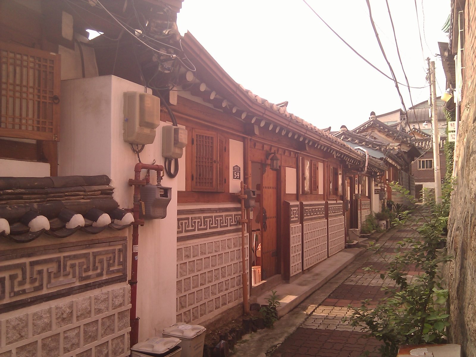 A quiet stone-paved alley between traditional hanok houses in Bukchon