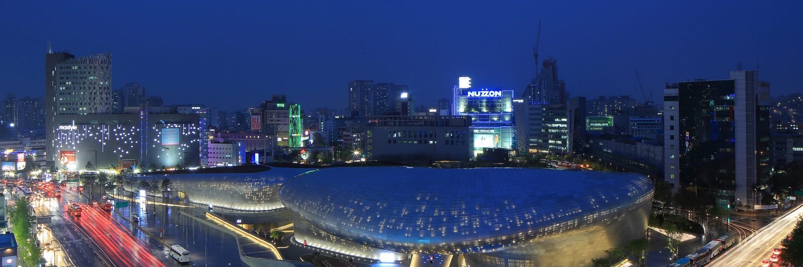 Dongdaemun Design Plaza illuminated at night with its curved panels lit up