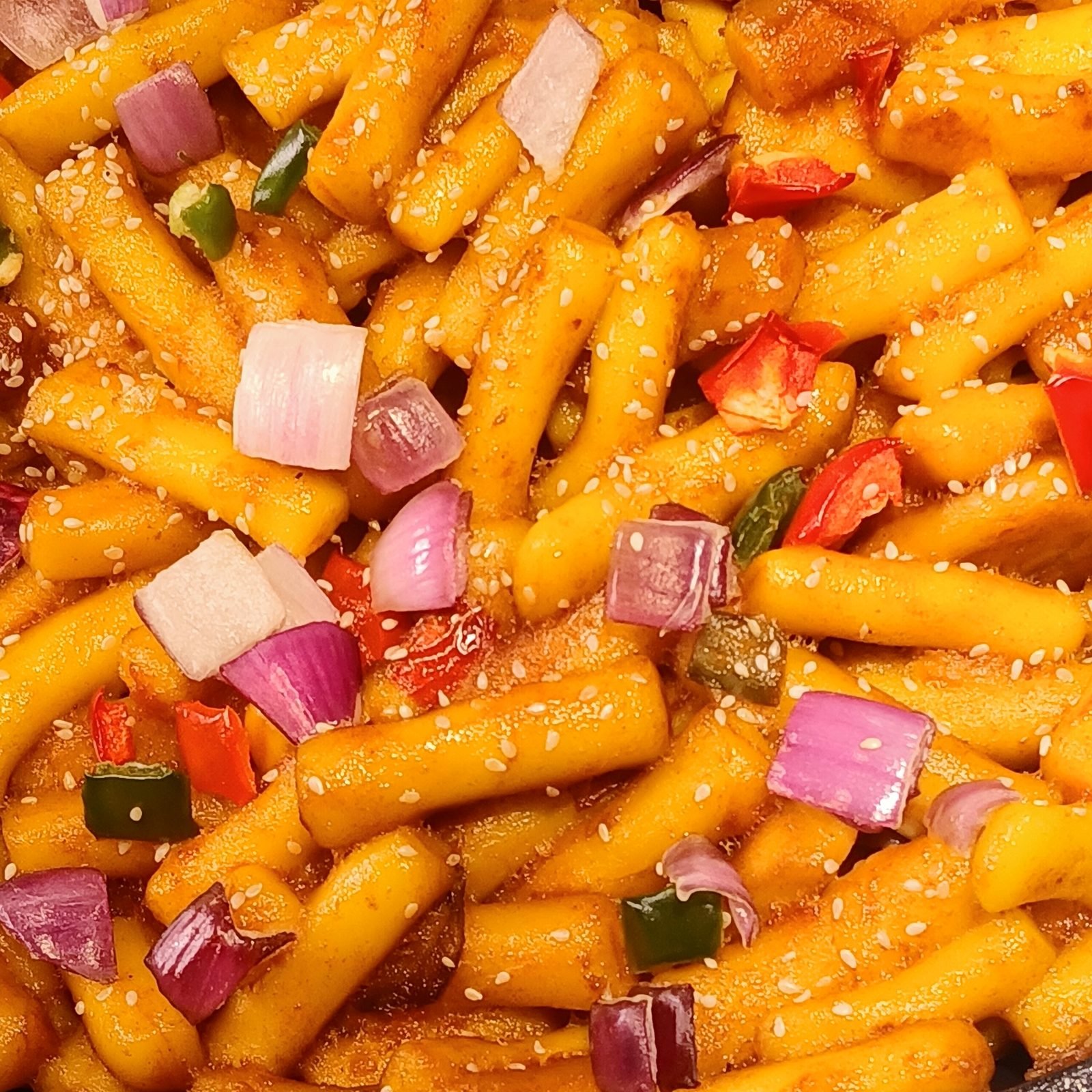 A plate of tteokbokki, chewy rice cakes in a red chili sauce