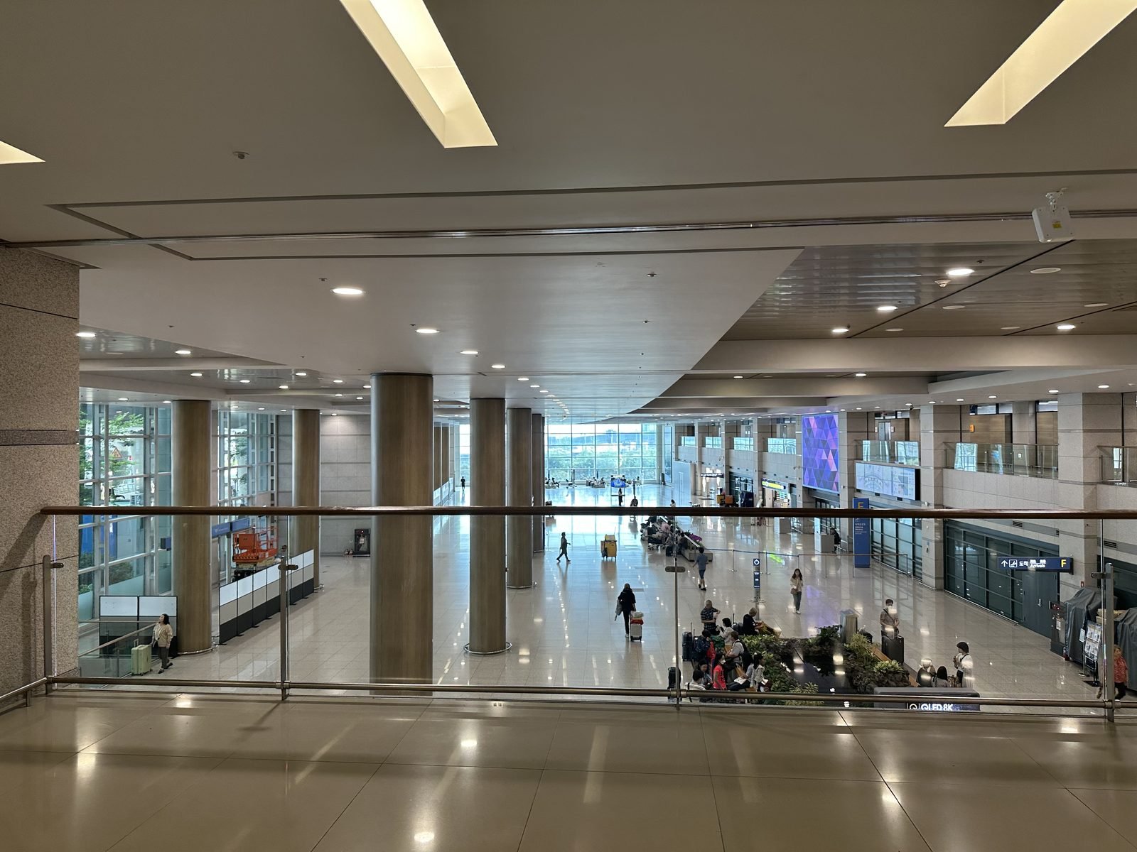 The arrivals area of Incheon International Airport Terminal 1 seen from a walkway above the hall