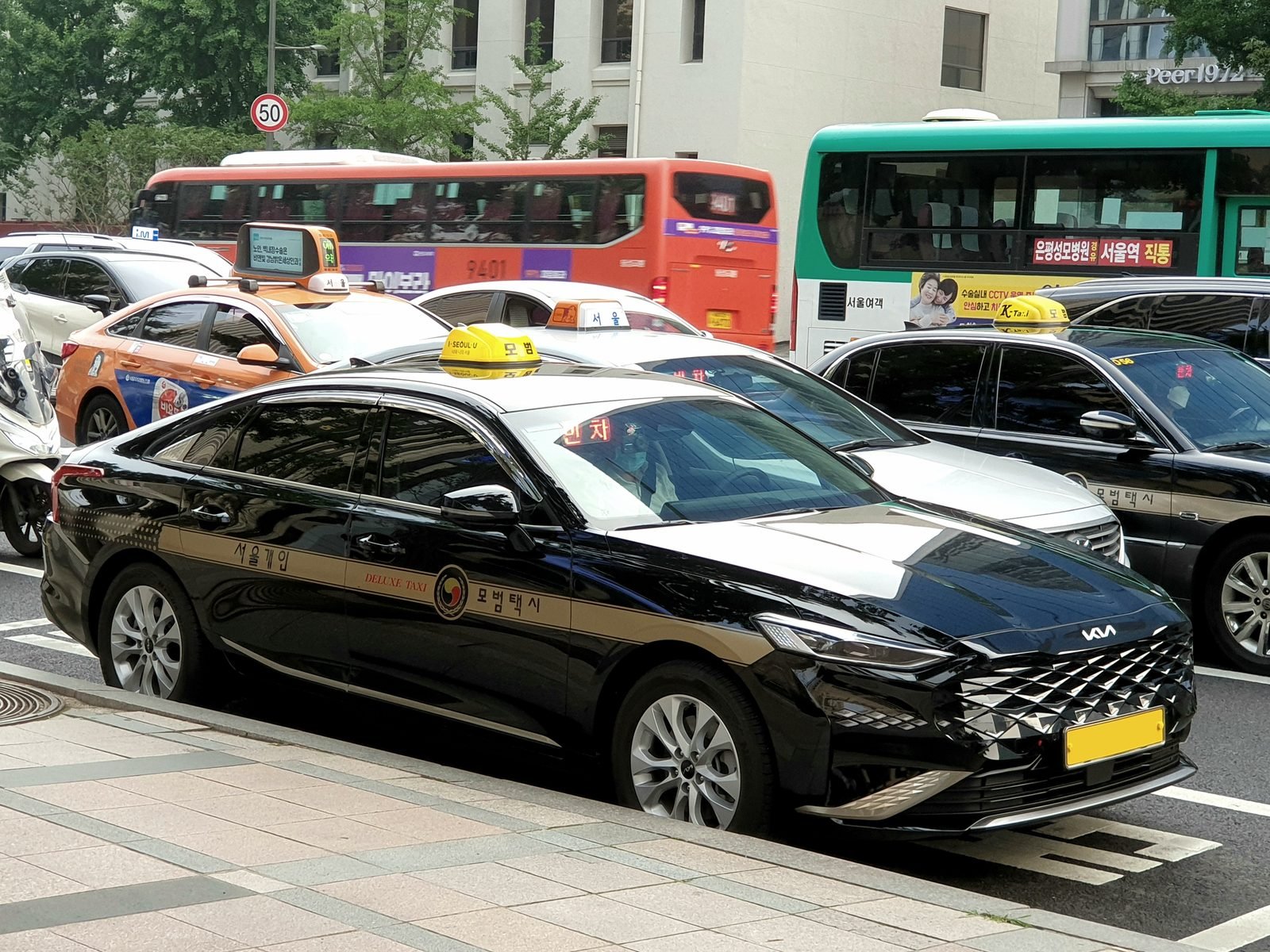 A black Kia K8 deluxe taxi in Seoul